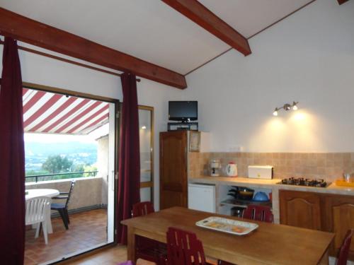 une cuisine et une salle à manger avec une table et un balcon dans l'établissement Colocha, à Cargèse