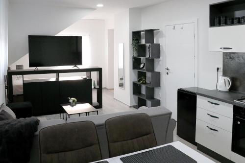 een woonkamer met een bank en een tv bij Apartmani i sobe Laganini in Nova Gradiška