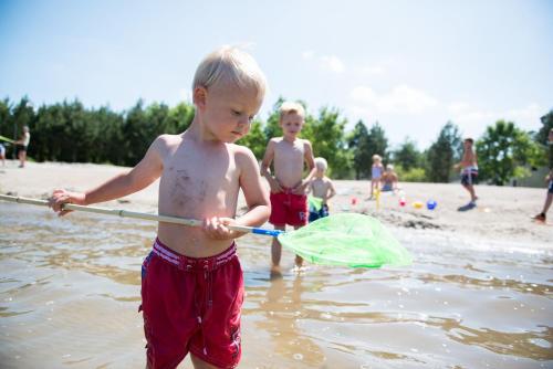 three young boys playing in the water at the beach at Sunparks Kempense Meren in Mol