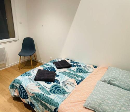 um quarto com uma cama e uma cadeira azul em Agréable T3 - 70m2 avec petite terrasse em Granges-lès-Valence