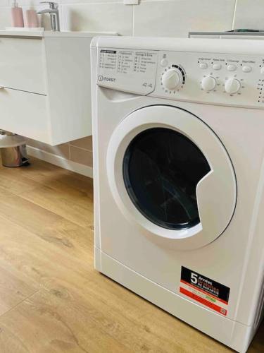 Un lave-linge blanc est installé dans la cuisine. dans l'établissement Agréable T3 - 70m2 avec petite terrasse, à Granges-lès-Valence