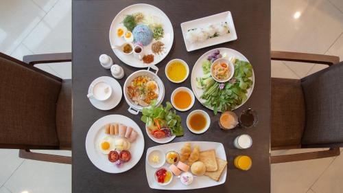 a table with many plates of food on it at Grand Fortune Hotel Nakhon Si Thammarat in Nakhon Si Thammarat