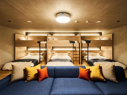 a bedroom with two beds and a couch with pillows at Rakuten STAY VILLA Awaji in Minamiawaji