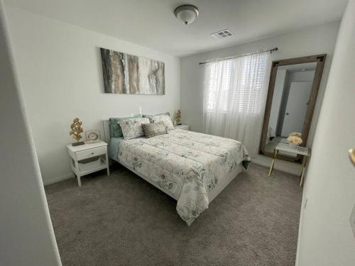 a white bedroom with a bed and a mirror at New,and Modern Home close to the strip in Las Vegas