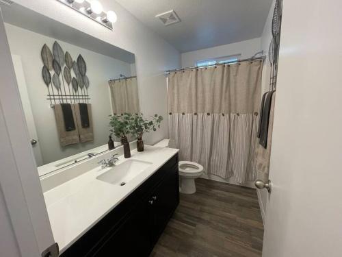 a bathroom with a sink and a toilet and a mirror at New,and Modern Home close to the strip in Las Vegas