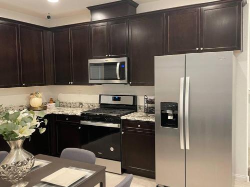 a kitchen with black cabinets and a stainless steel refrigerator at New,and Modern Home close to the strip in Las Vegas