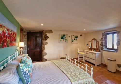 a bedroom with a bed and a dresser and a mirror at Casa Del Ingles - Luxury Private Village & Pool in Rural Valley in Pontevedra