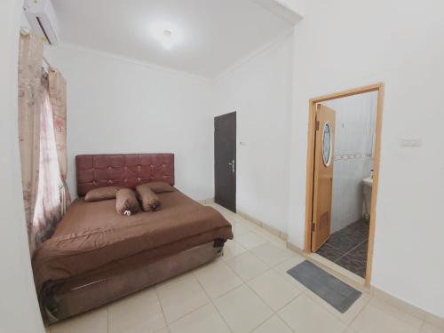 a bedroom with a bed in a room with a mirror at Rumah Lavender near OPI Mall Jakabaring in Palembang