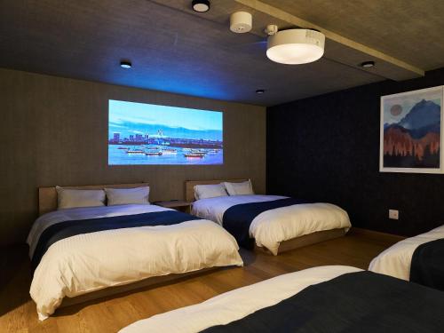 a room with three beds with a painting on the wall at Rakuten STAY VILLA Awaji in Minamiawaji
