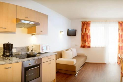 una pequeña cocina con sofá en una habitación en Appartement Nr 3 Alpenstern en Wagrain