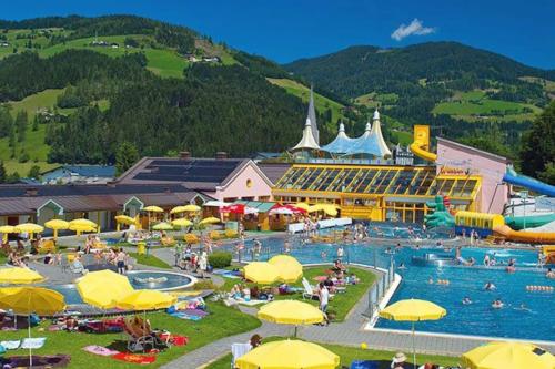 a resort with a large pool with people in it at Appartement Nr 3 Alpenstern in Wagrain