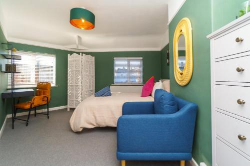 a bedroom with a bed and a blue chair at 4BR House | WiFi | Parking in Bristol