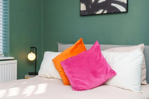 two colorful pillows sitting on top of a bed at 4BR House | WiFi | Parking in Bristol