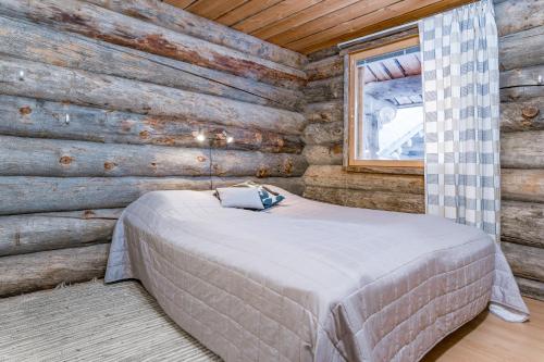 ein Schlafzimmer mit einem Bett in einer Blockhütte in der Unterkunft Ruka Inn in Ruka
