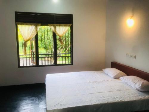 1 dormitorio con cama blanca y ventana en Laughing Jungle Unawatuna, en Galle