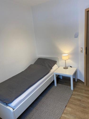 1 dormitorio con 1 cama y 1 mesa con lámpara en Ferienwohnung Kornkäfer 3, en Döbeln