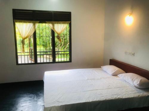高爾的住宿－Laughing Jungle Unawatuna，卧室配有白色的床和窗户。