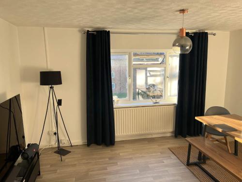 ein Wohnzimmer mit schwarzen Vorhängen, einem Tisch und einem Fenster in der Unterkunft Cheltenham ,Gloucestershire,United Kingdom 