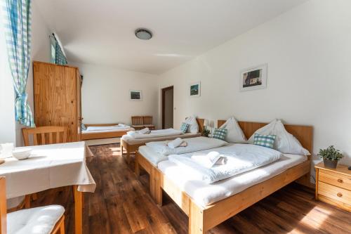 Zimmer mit 2 Betten und einem Tisch in der Unterkunft Penzion Starý Pivovar in Kiritein
