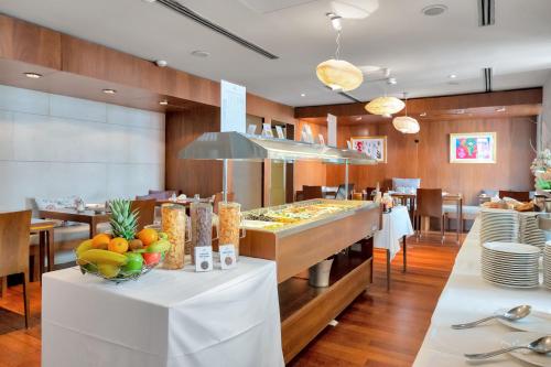 a restaurant with a buffet with fruit on a table at Hotel Beau Rivage in Nice