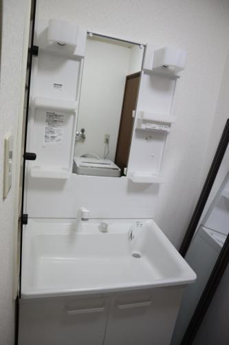 a bathroom with a white sink and a mirror at STAY Moiwayama in Sapporo