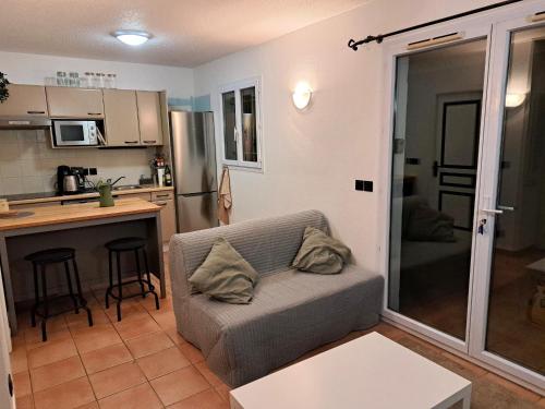 ein Wohnzimmer mit einem Sofa und einer Küche in der Unterkunft NOUVEAU! Maison 2 pcs mezzanine dans résidence avec piscine in Tourrettes