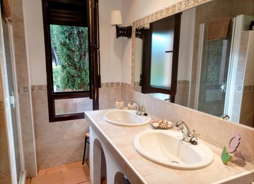 un bagno con due lavandini e uno specchio di Casa rural El Pitañar a Teruel