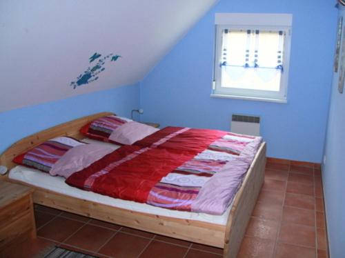 a bedroom with a wooden bed with a red blanket at Ferienhaus Sonnenschein in Breege in Juliusruh
