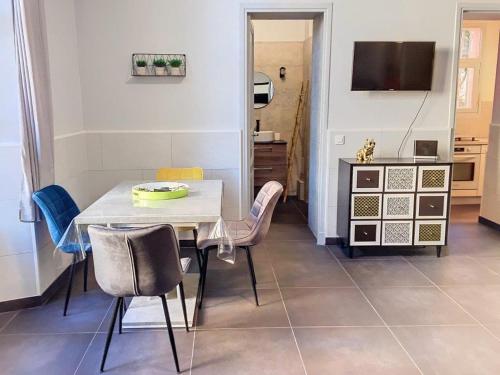 une salle à manger avec une table et des chaises et une télévision dans l'établissement Charmant studio, à Cannes