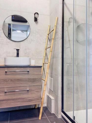 - une échelle dans une salle de bains pourvue d'un lavabo et d'un miroir dans l'établissement Charmant studio, à Cannes