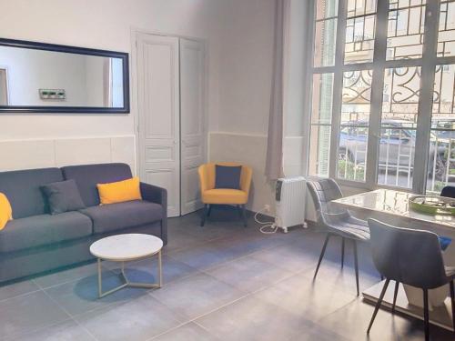 ein Wohnzimmer mit Sofa, Tisch und Stühlen in der Unterkunft Charmant studio in Cannes