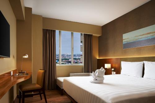 a hotel room with a bed and a window at eL Hotel Jakarta in Jakarta