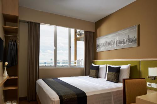 a hotel room with a bed with a large window at eL Hotel Jakarta in Jakarta