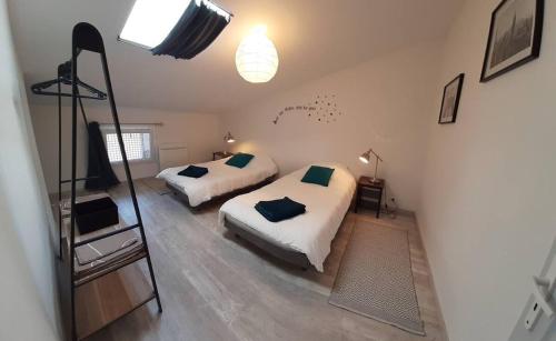 um quarto com duas camas e uma televisão em Chambre dans le centre historique em Bourg-Saint-Andéol