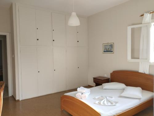 a white bedroom with a bed with towels on it at Assos Beach in Káto Ássos