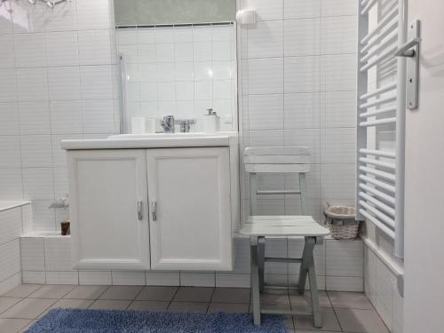 een witte badkamer met een wastafel en een kruk bij Appartamento vista splendida Residence du Golf in Golfe-Juan