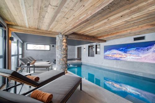 une maison avec une piscine et une télévision dans l'établissement Chalet Eden Roc, à Tignes