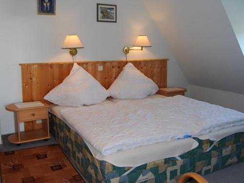 ein Schlafzimmer mit einem Bett mit zwei Kissen darauf in der Unterkunft Ferienwohnung Rügen mit Ostseeblick in Dranske
