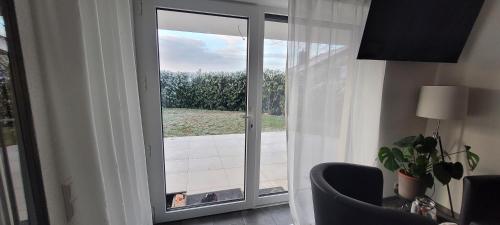 a living room with a large glass door with a window at Studio / Ferienwohnung Bamlach in Bad Bellingen