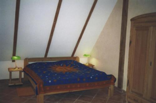 Schlafzimmer mit einem Bett mit blauer Decke in der Unterkunft Ferienwohnung Rügen in Putgarten in Putgarten