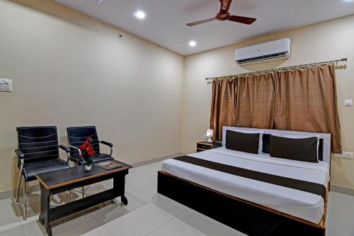 a bedroom with a bed and a table and two chairs at Archie Oasis in Bhubaneshwar