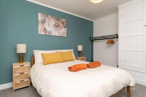 a bedroom with a white bed and a blue wall at WiFi | Parking | Near Major Attractions in Bath