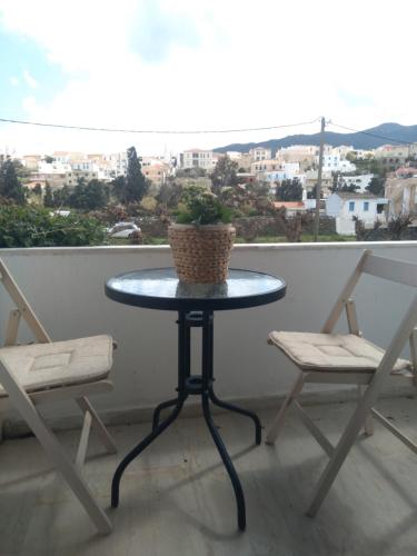 una mesa con una maceta en un balcón con 2 sillas en Iokasti studio 4, en Ándros