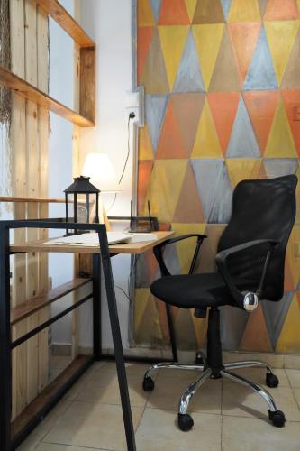a desk with a chair in front of a colorful wall at ΩκεανιςHouse 1 in Preveza