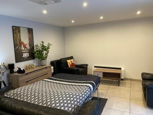 ein Schlafzimmer mit einem Bett, einem Sofa und einem Stuhl in der Unterkunft Dépendance privative dans villa in Genay