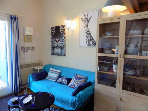 un salon avec un canapé bleu et une table dans l'établissement Saint Palais sur Mer - MAISON MITOYENNE de VACANCES - VILLAS de CORDOUAN, à Puyraveau