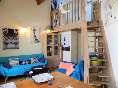 - un salon avec un canapé bleu et un escalier dans l'établissement Saint Palais sur Mer - MAISON MITOYENNE de VACANCES - VILLAS de CORDOUAN, à Puyraveau