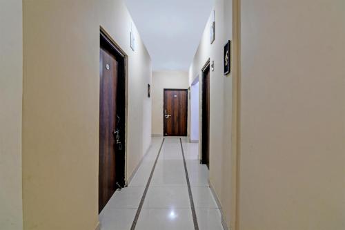 un corridoio con 2 porte e pavimento piastrellato di OYO Archie Oasis a Bhubaneshwar