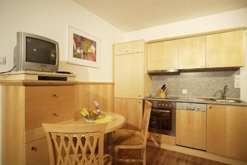 a kitchen with a small table and a tv on top at Falkner Appartement Resort in Längenfeld