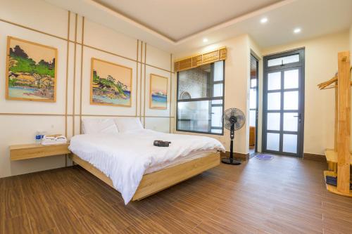 a bedroom with a large bed and a fan at AN PHÚ Home in Da Lat